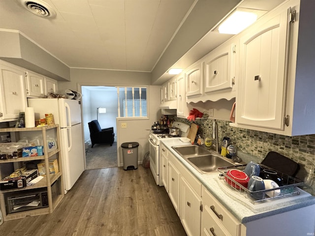 kitchen featuring white appliances, backsplash, white cabinets, sink, and dark hardwood / wood-style flooring