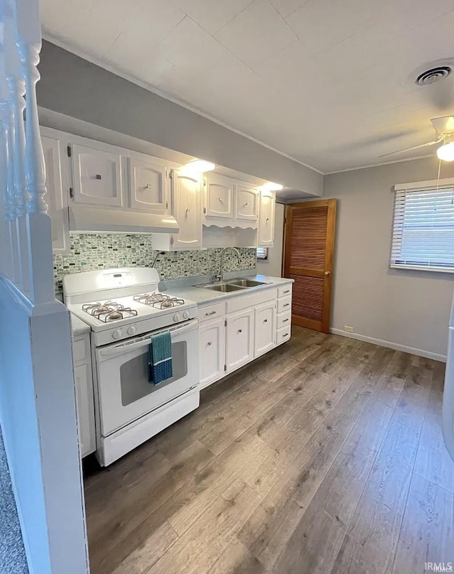 kitchen with tasteful backsplash, white range with gas cooktop, sink, and white cabinets