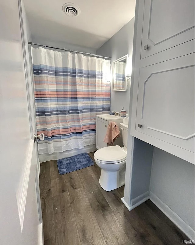 full bathroom with wood-type flooring, vanity, toilet, and shower / bath combo with shower curtain