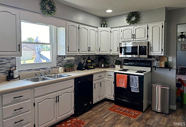 kitchen with dark wood-style floors, a sink, electric stove, dishwasher, and stainless steel microwave