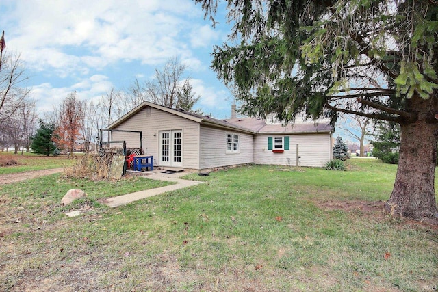 back of property featuring a yard and french doors