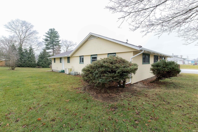 view of home's exterior with central AC unit and a yard