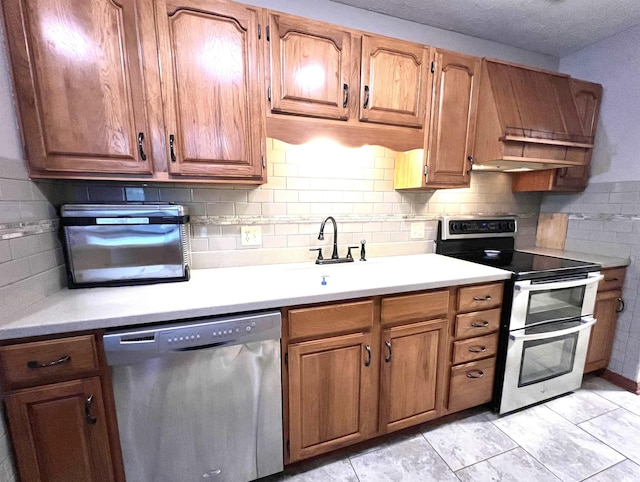 kitchen featuring tasteful backsplash, sink, light tile patterned flooring, and appliances with stainless steel finishes