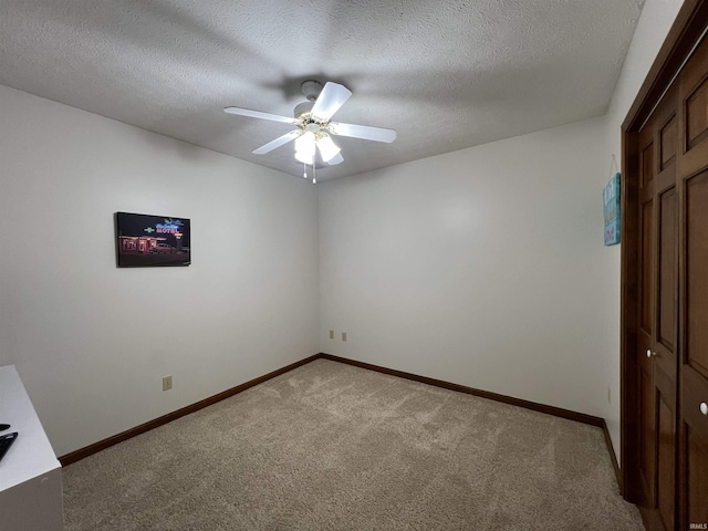 unfurnished room featuring a textured ceiling, ceiling fan, and light carpet