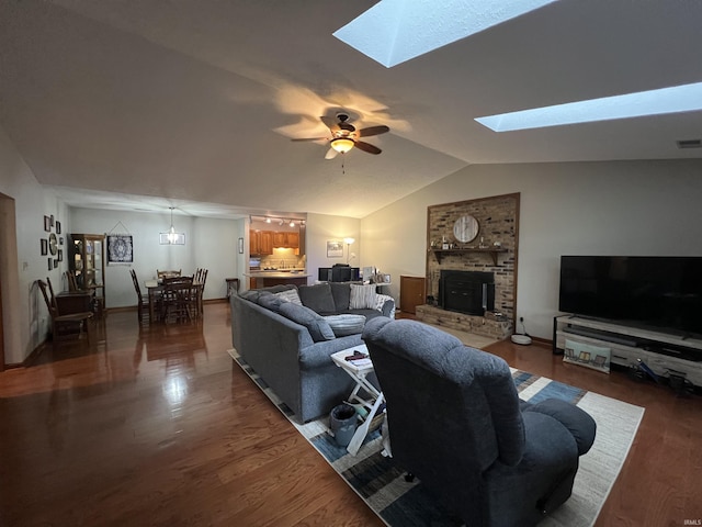 living room featuring dark hardwood / wood-style flooring, lofted ceiling with skylight, and ceiling fan