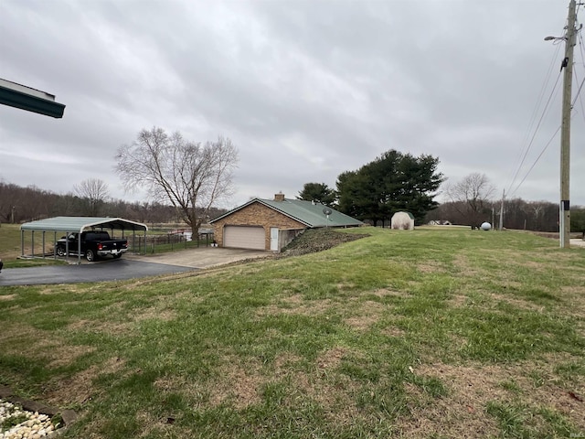 view of yard featuring a carport and a garage