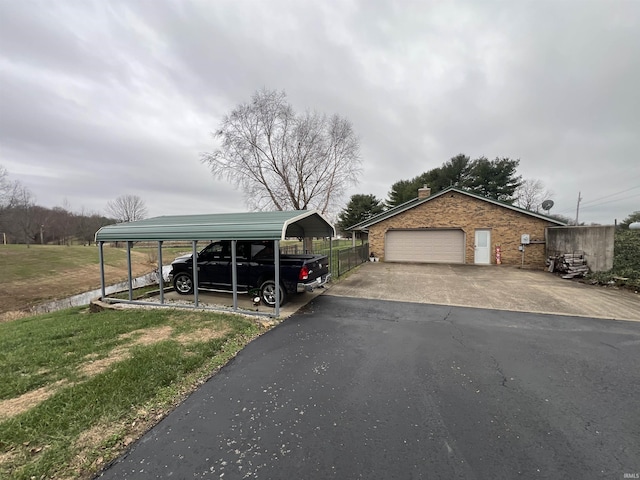 exterior space featuring a carport, a garage, and a lawn