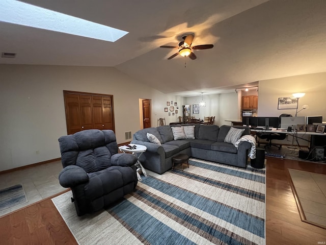 living room with ceiling fan, lofted ceiling, and light hardwood / wood-style flooring