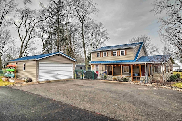 view of front of house featuring an outbuilding, covered porch, and a garage