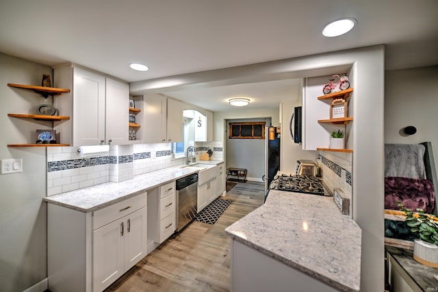 kitchen with white cabinetry, light stone counters, and stainless steel appliances