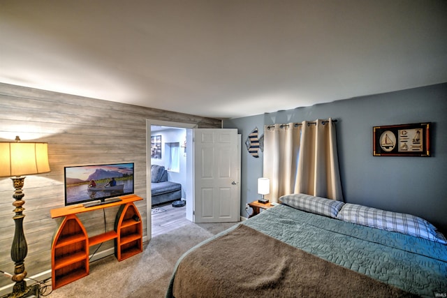 carpeted bedroom featuring wooden walls