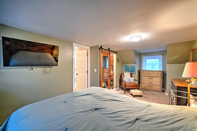 carpeted bedroom with a barn door