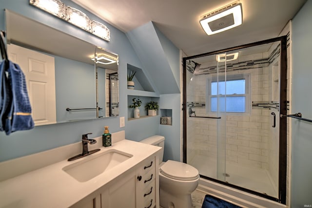 bathroom with a shower with door, vanity, and toilet