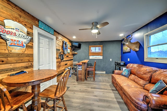 dining space with ceiling fan, light hardwood / wood-style floors, and a baseboard heating unit