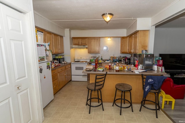 kitchen featuring white appliances, crown molding, a textured ceiling, a kitchen bar, and kitchen peninsula