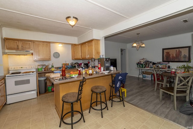 kitchen with white electric stove, kitchen peninsula, pendant lighting, a chandelier, and a kitchen bar