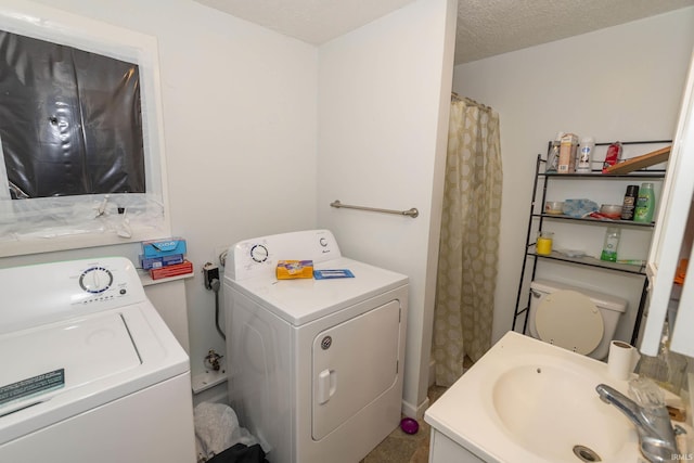 bathroom with separate washer and dryer, sink, a textured ceiling, and toilet