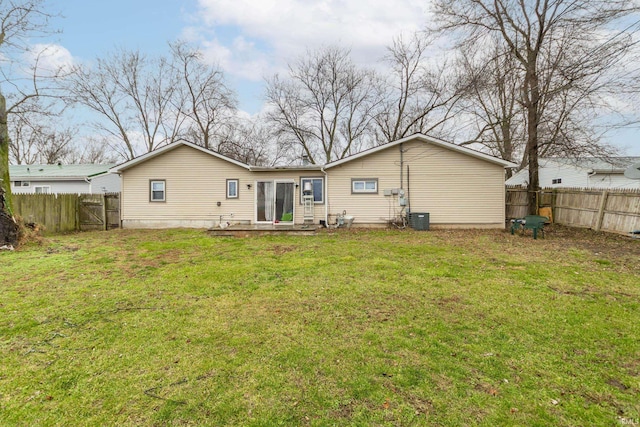 rear view of property with a lawn and central air condition unit