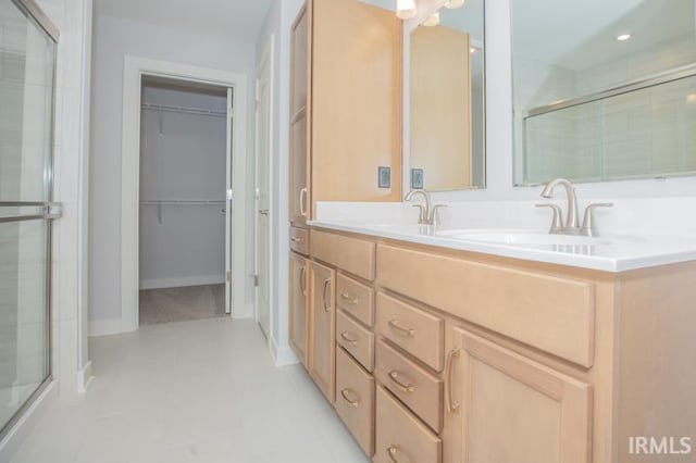 bathroom with vanity, tile patterned floors, and a shower with door