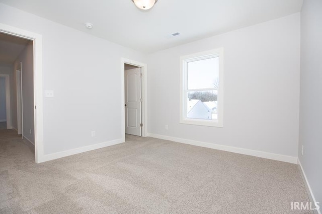 unfurnished room featuring light carpet