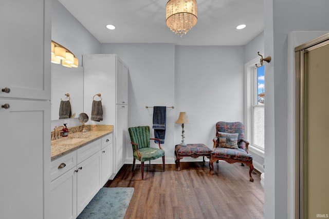 interior space featuring a notable chandelier, vanity, and wood-type flooring