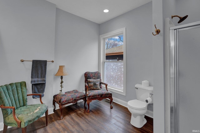 living area with a healthy amount of sunlight and dark hardwood / wood-style flooring