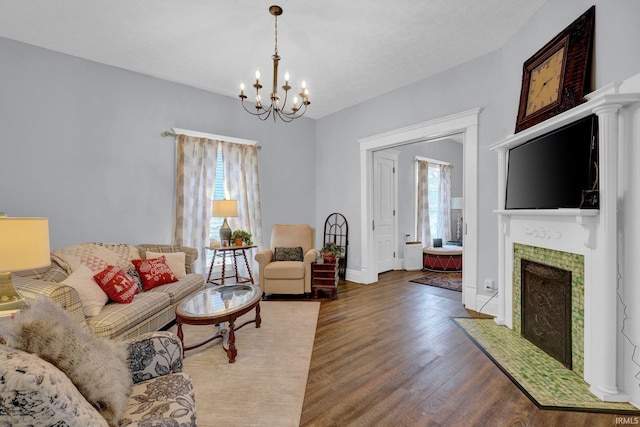 living room with a tile fireplace, dark hardwood / wood-style flooring, and an inviting chandelier