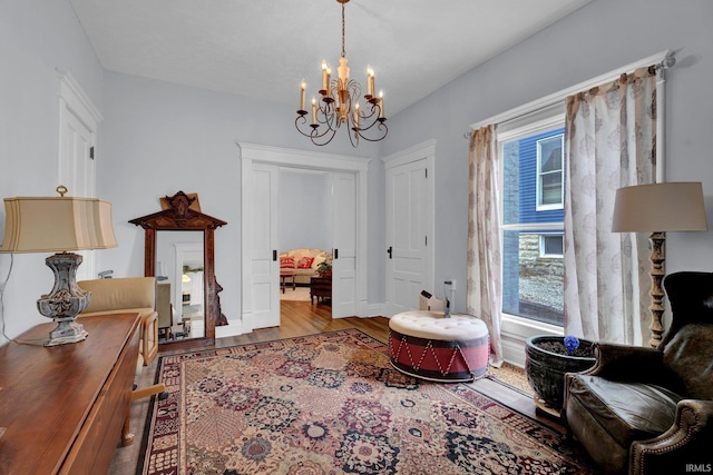 sitting room with hardwood / wood-style flooring and an inviting chandelier