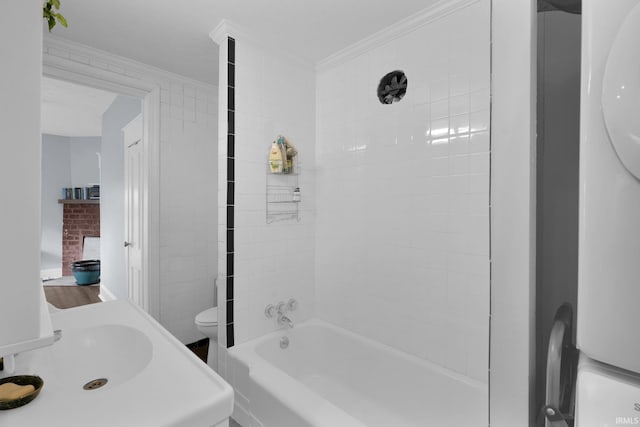 bathroom featuring toilet, tiled shower / bath, and ornamental molding