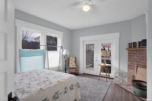 bedroom with access to exterior, ceiling fan, french doors, wood-type flooring, and a textured ceiling