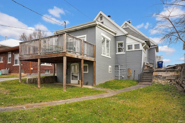 rear view of property with a deck and a yard