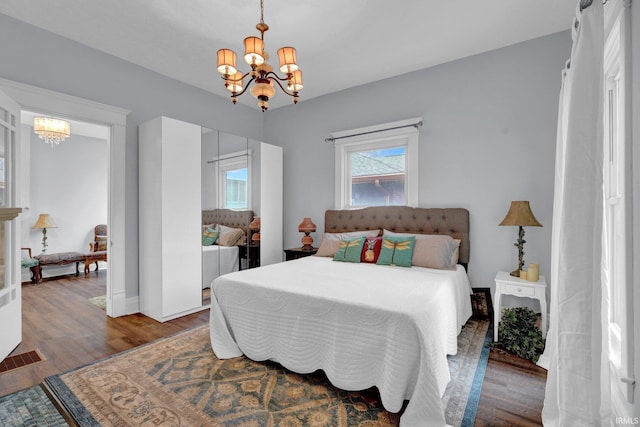 bedroom with a chandelier and dark hardwood / wood-style floors