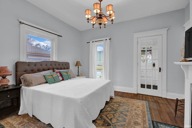 bedroom with dark hardwood / wood-style floors and an inviting chandelier