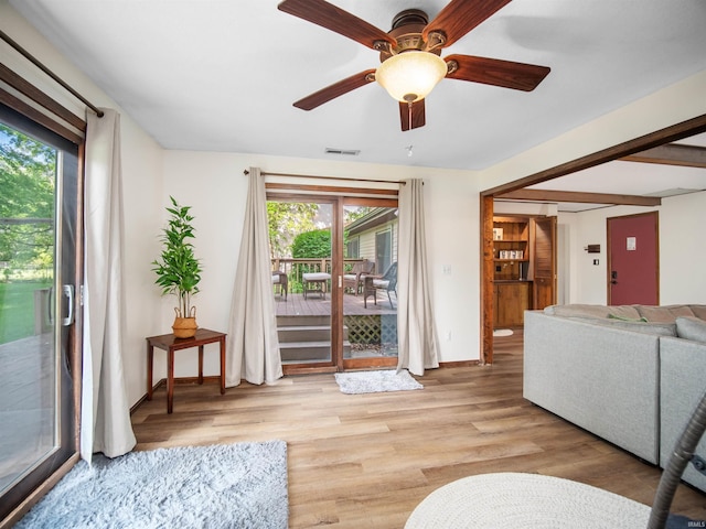 living room featuring light hardwood / wood-style flooring and ceiling fan