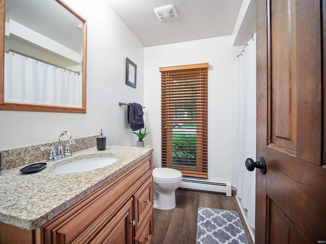 bathroom with toilet, vanity, a baseboard radiator, and wood-type flooring