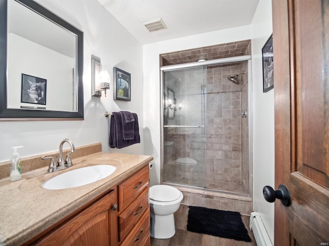 bathroom with vanity, toilet, a baseboard radiator, an enclosed shower, and wood-type flooring