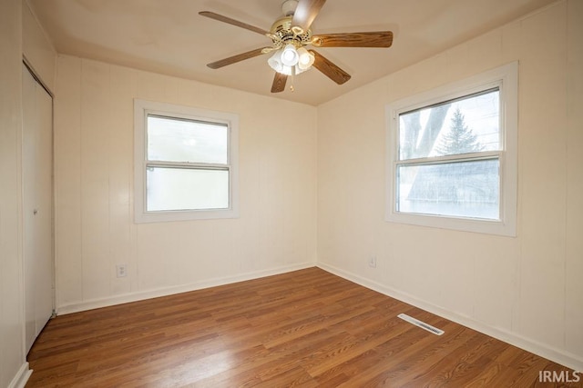 empty room with ceiling fan and hardwood / wood-style flooring