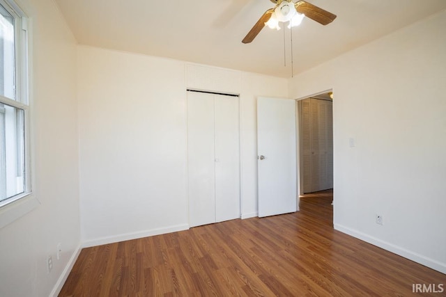 unfurnished bedroom with hardwood / wood-style flooring, ceiling fan, and a closet