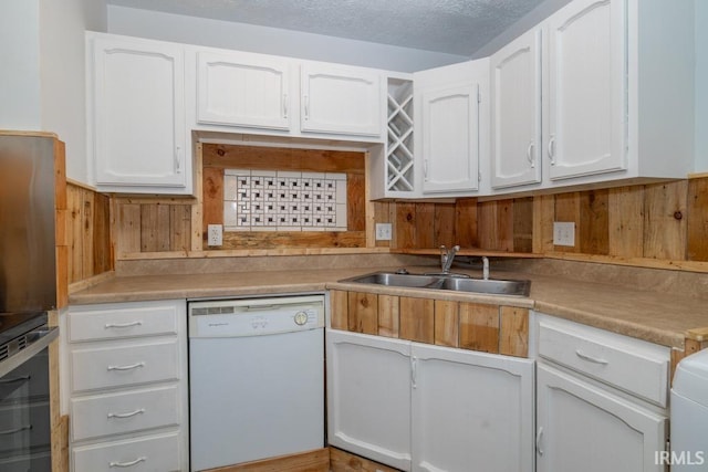 kitchen with stove, white cabinets, a textured ceiling, sink, and dishwasher