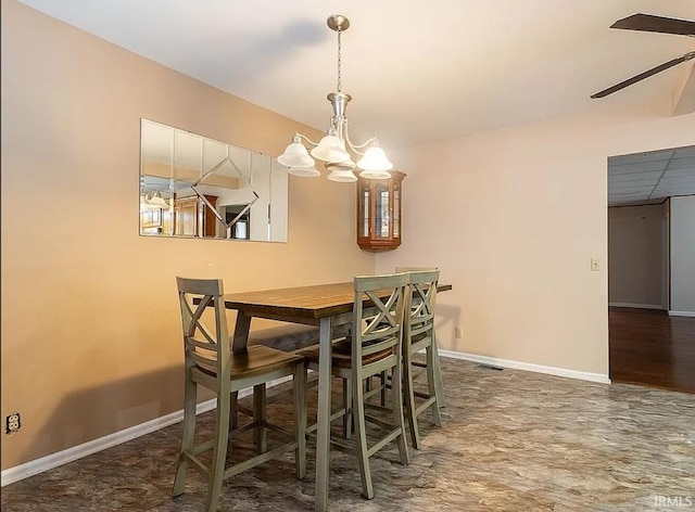 dining space with ceiling fan with notable chandelier