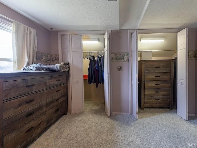 bedroom with light carpet, a textured ceiling, a spacious closet, and a closet