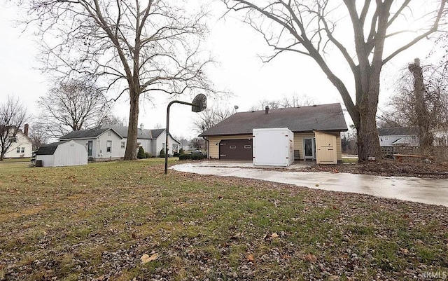 back of property featuring a lawn and a storage shed