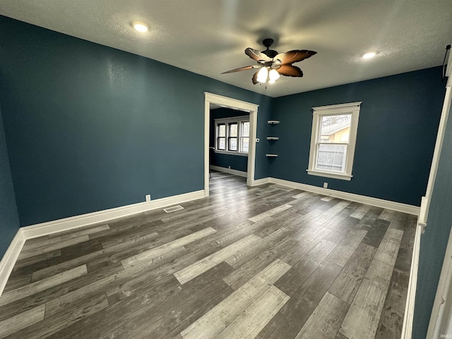 empty room featuring ceiling fan, wood-type flooring, and a textured ceiling