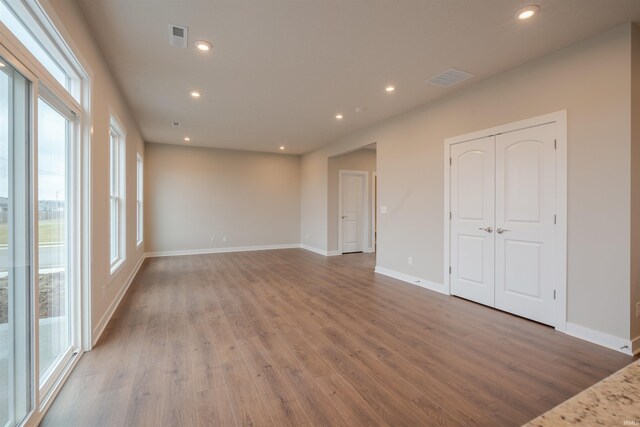 unfurnished room with hardwood / wood-style floors and a healthy amount of sunlight