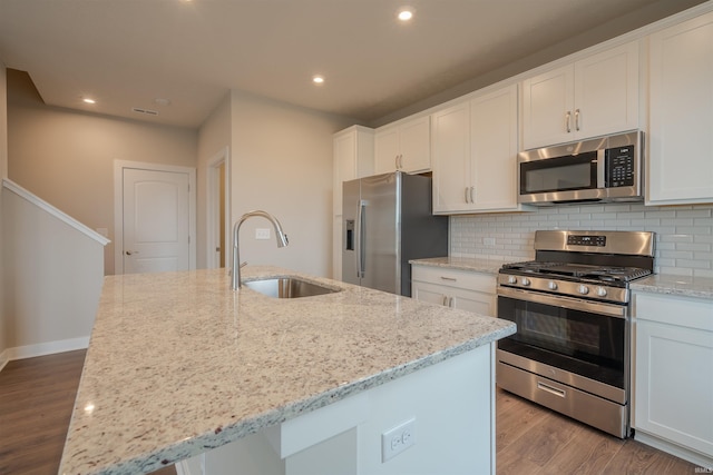 kitchen featuring white cabinetry, a kitchen island with sink, sink, and appliances with stainless steel finishes