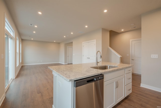 kitchen featuring light stone countertops, stainless steel dishwasher, sink, a center island with sink, and white cabinetry