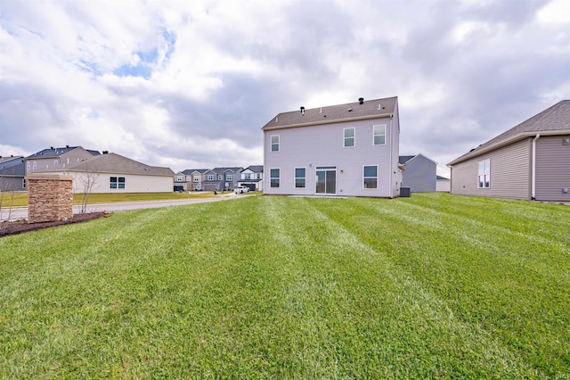 rear view of property featuring a lawn