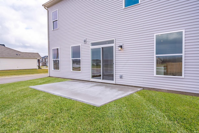 rear view of house featuring a lawn and a patio