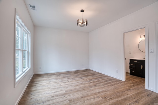 spare room with light wood-type flooring and plenty of natural light