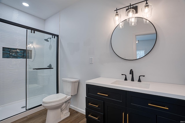 bathroom with hardwood / wood-style floors, vanity, and an enclosed shower